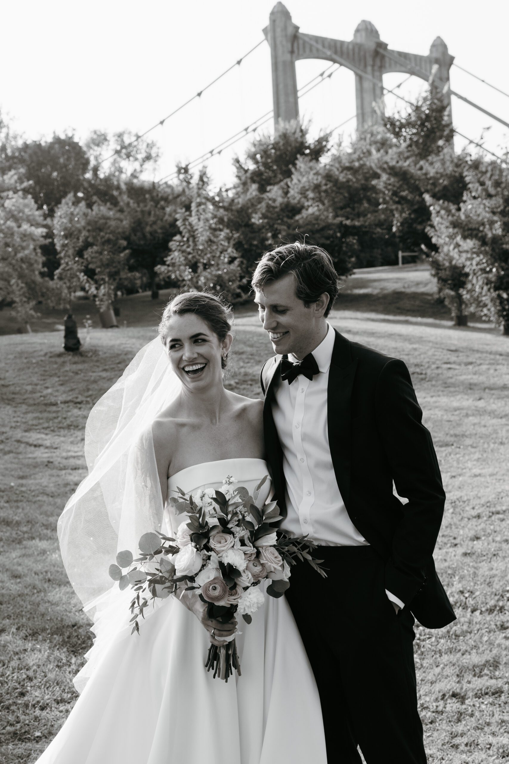 Bride and groom on their wedding day laughing outside their wedding venue: Nicollet Island Pavilion